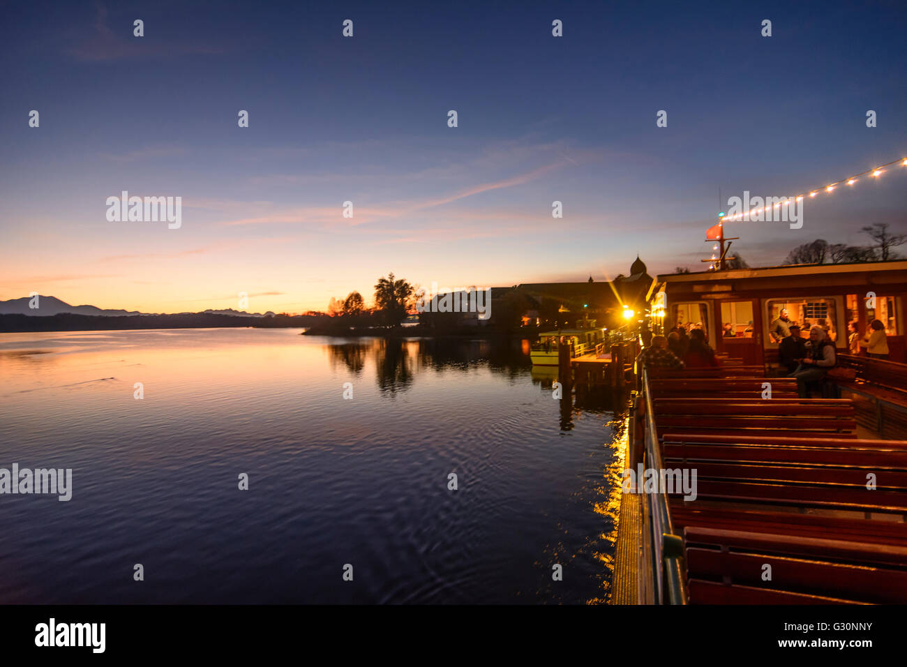 View from a passenger ship at the pier of the Fraueninsel in the Chiemsee and the Alps at sunset, Germany, Bayern, Bavaria, Ober Stock Photo