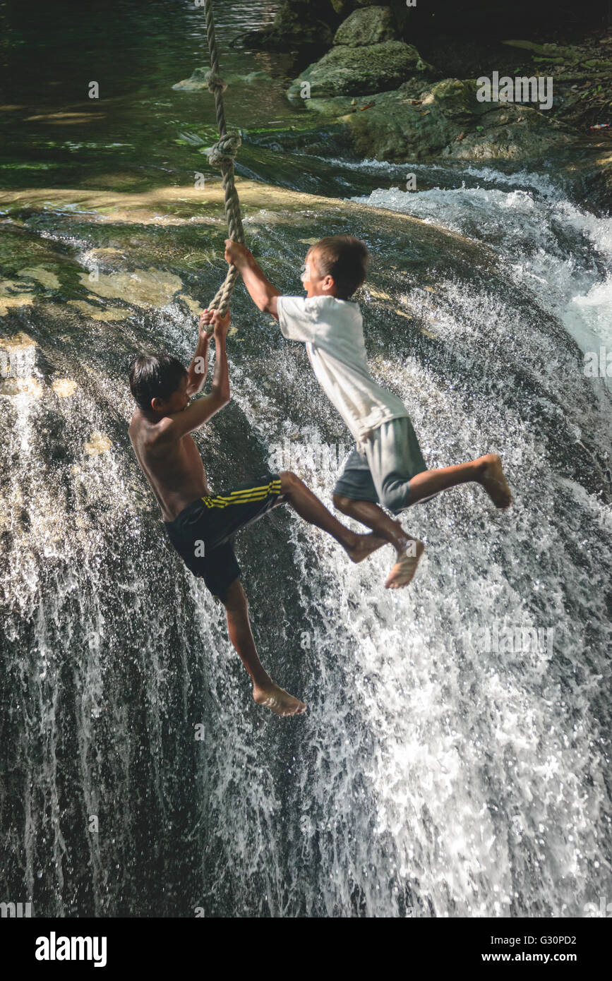 Local kids playing at a waterfall in Moyo Island Stock Photo