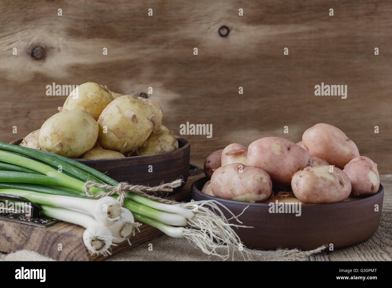 Raw organic potatoes and spring green onion. Red potatoes, yellow