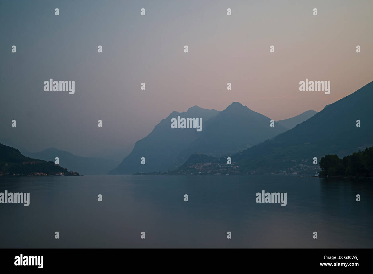 Tranquility over alpine mountains and villages and Lake Iseo at dawn in spring,Lombardy,Italy Stock Photo
