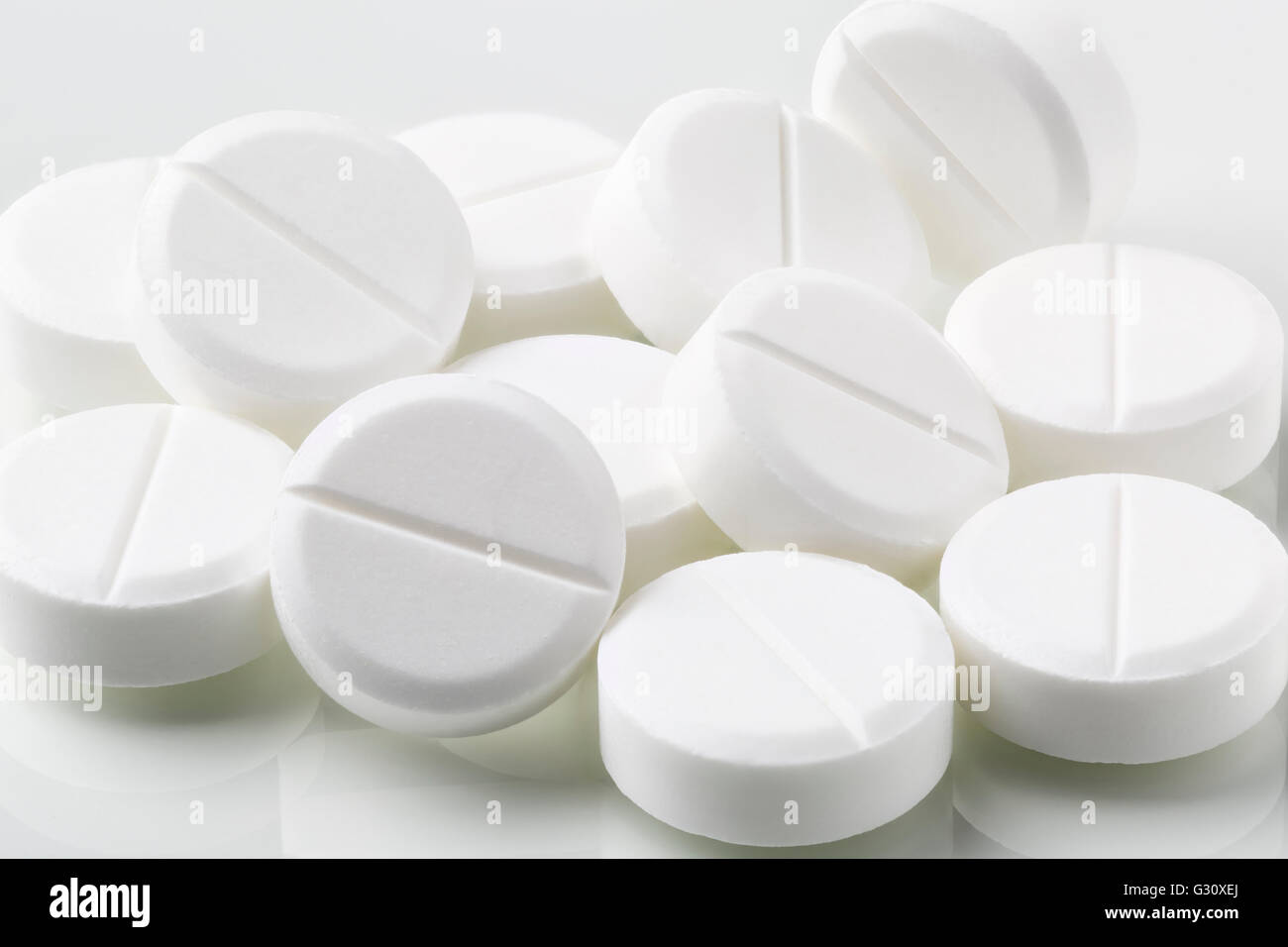 Bunch of white round pills and drugs on white background Stock Photo