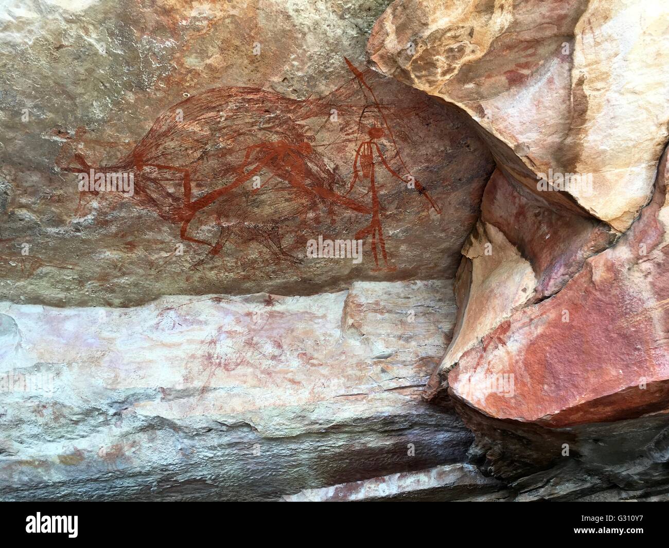 A rock wallaby with human figures painted in a cave at 'The Castle' at Gubara in Kakadu National Park, Australia. Stock Photo