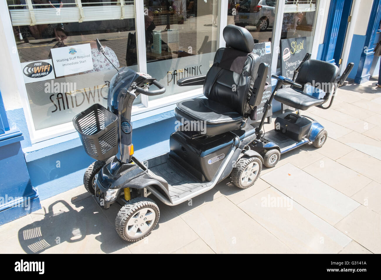 Mobility scooters parked up outside cafe In coastal resort town of