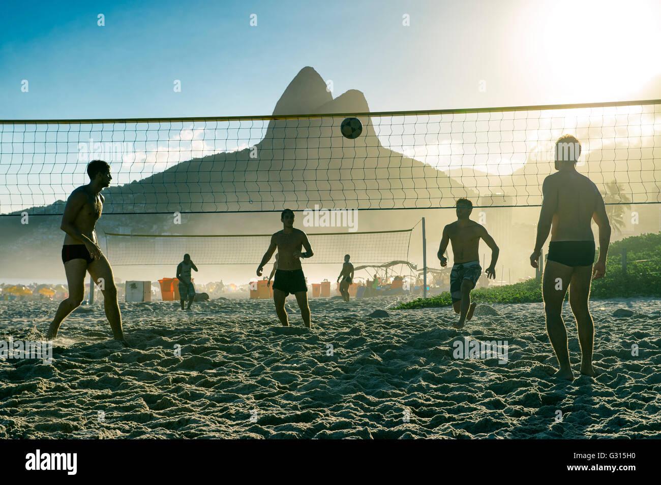 RIO DE JANEIRO - MARCH 27, 2016: Brazilians play beach futevôlei (footvolley, a sport combining football/soccer and volleyball). Stock Photo
