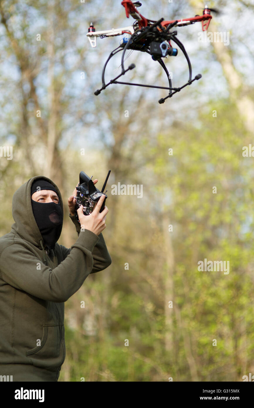 Man in mask operating a drone with remote control. Stock Photo