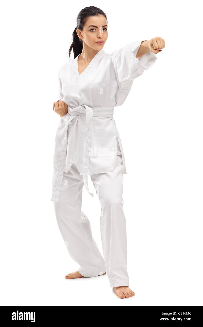 Full length portrait of a young female martial artist punching isolated