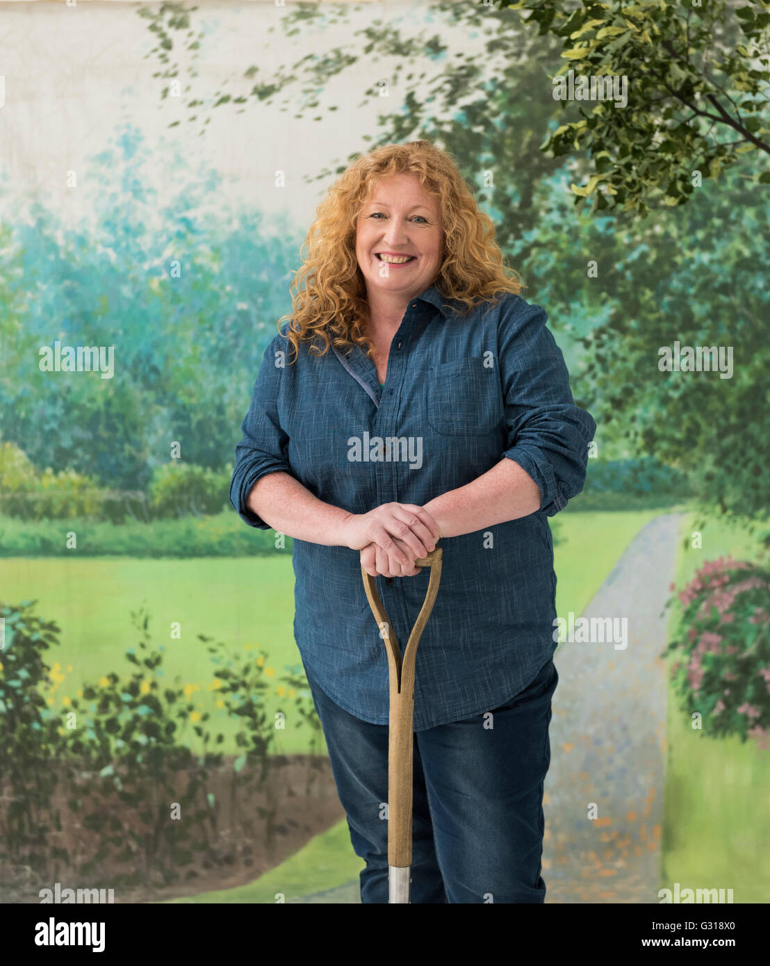 Charlie Dimmock holding a spade against a backdrop of an English summer garden. Stock Photo