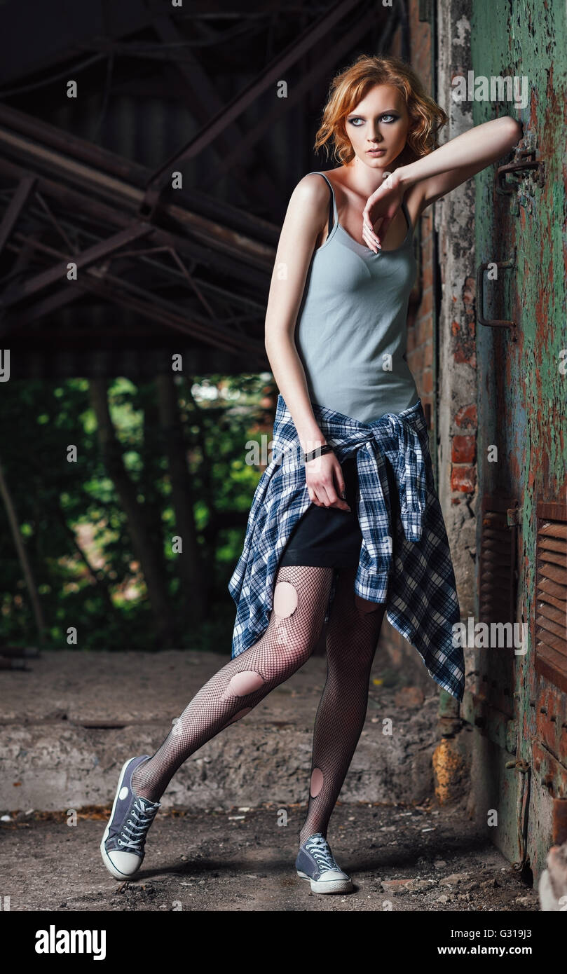 Portrait of a lovely young grunge girl in checkered shirt and torn pantyhose Stock Photo