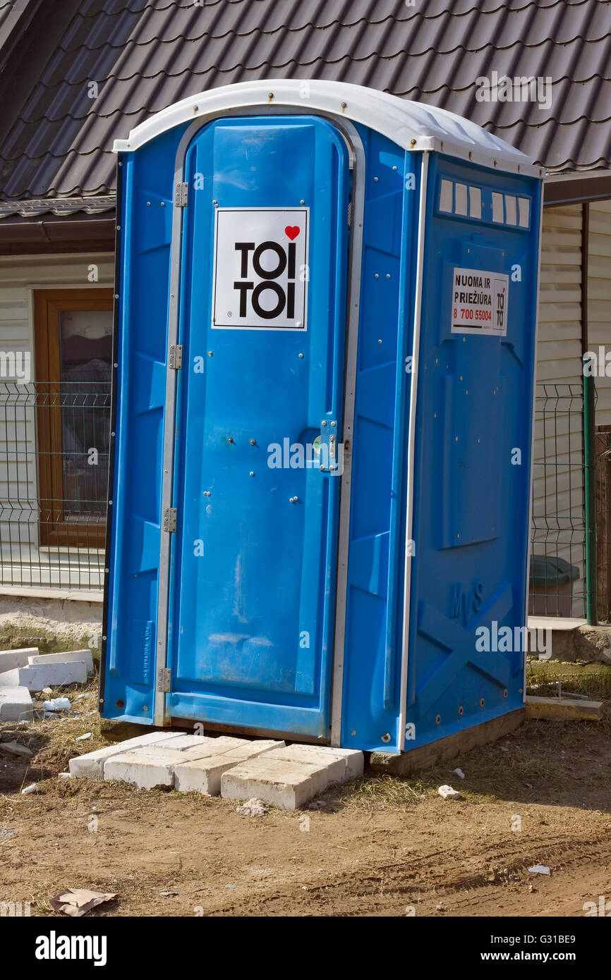 VILNIUS, LITHUANIA - MARCH 28, 2016: Blue cabin of a mobile bio toilet of the Toi Toi brand near the under construction house in Stock Photo