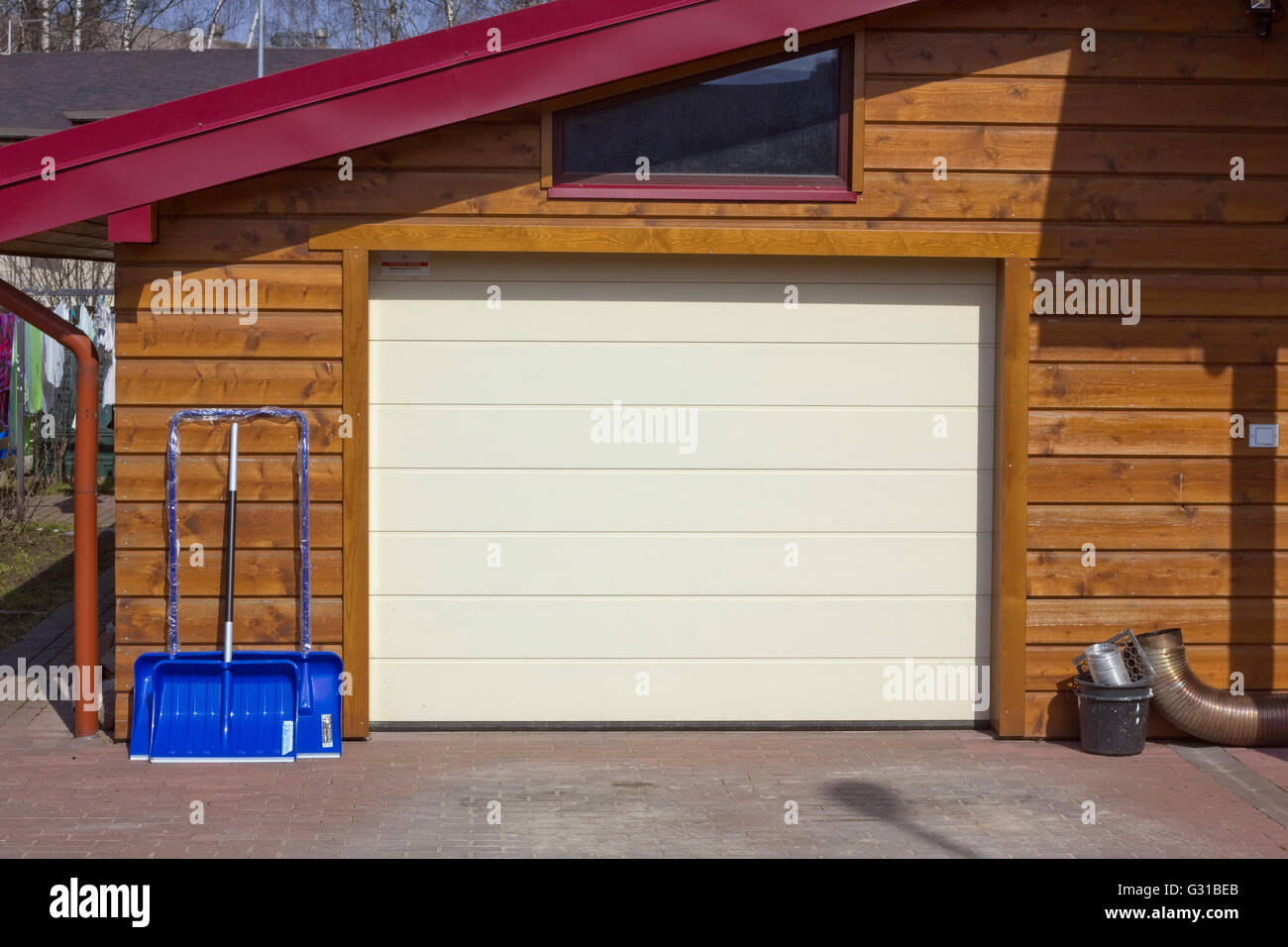 VILNIUS, LITHUANIA - MARCH 28, 2016: Blue Gardena shovels for cleaning of snow at a wall of rural garage. The Gardena brand, has Stock Photo