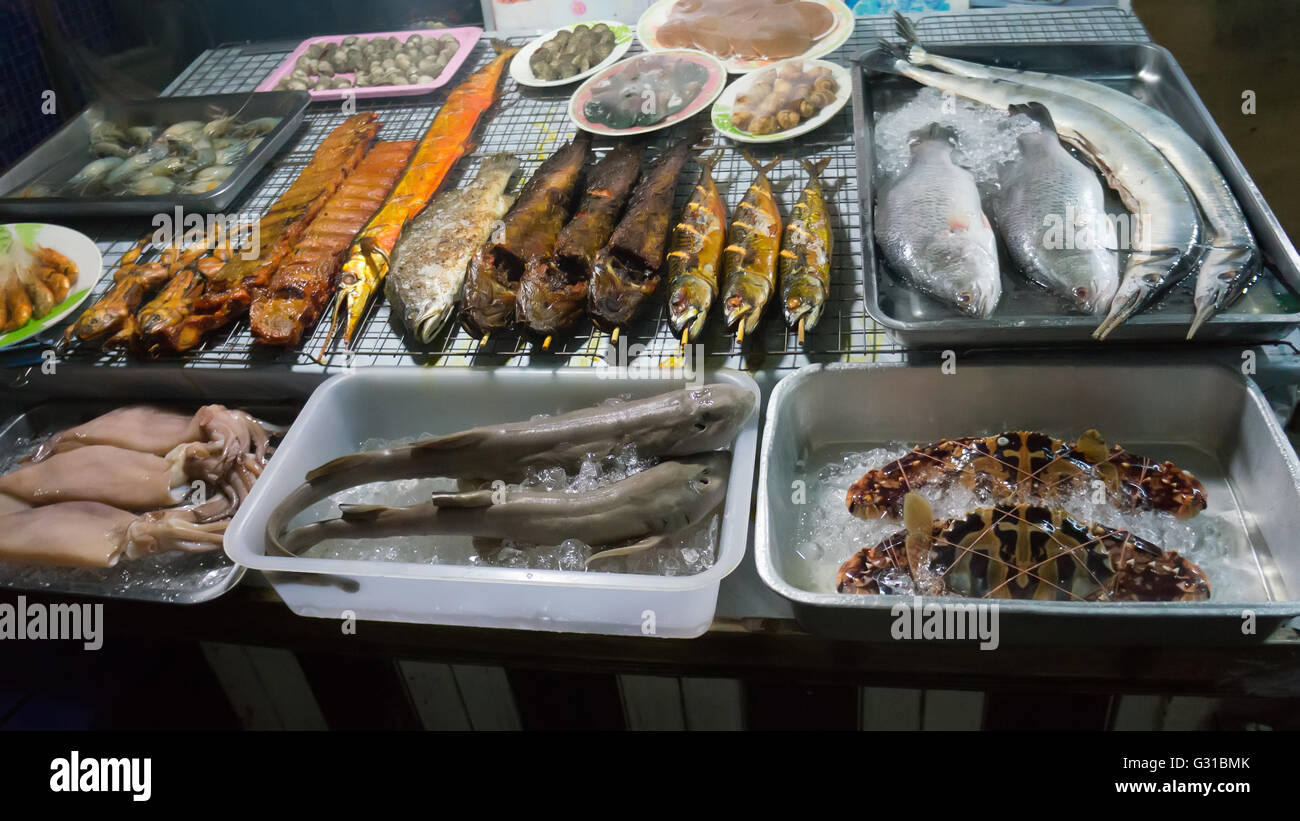 Thai street sea foods on trays at Pattaya market, Thailand Stock Photo