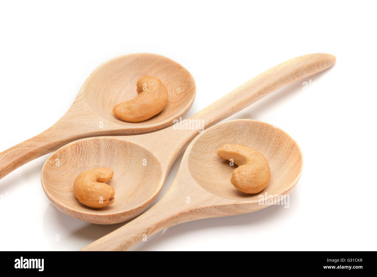 cashew nuts in spoon on wood arrange on white background Stock Photo