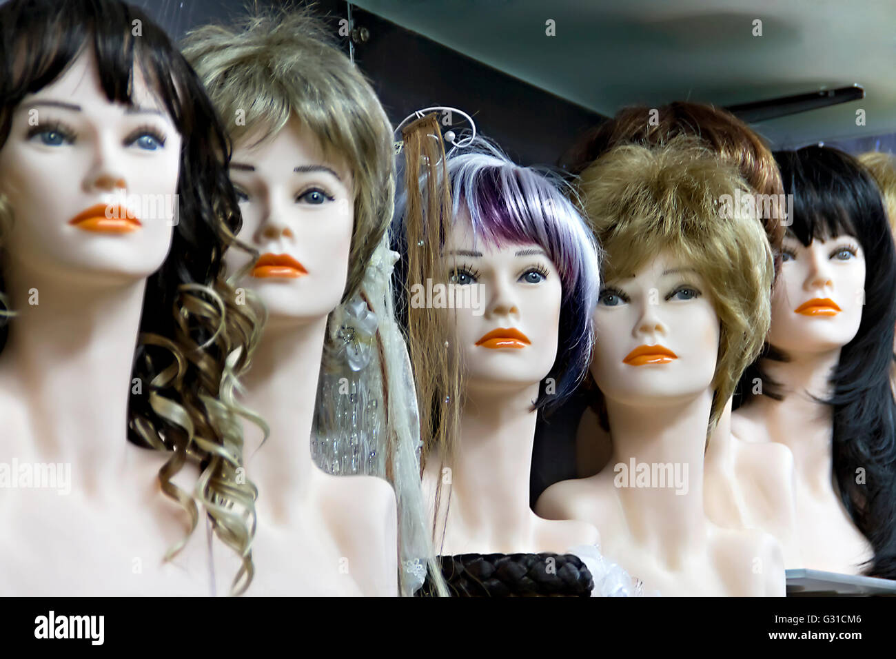 Several female mannequins with wigs on the shelf Stock Photo Alamy