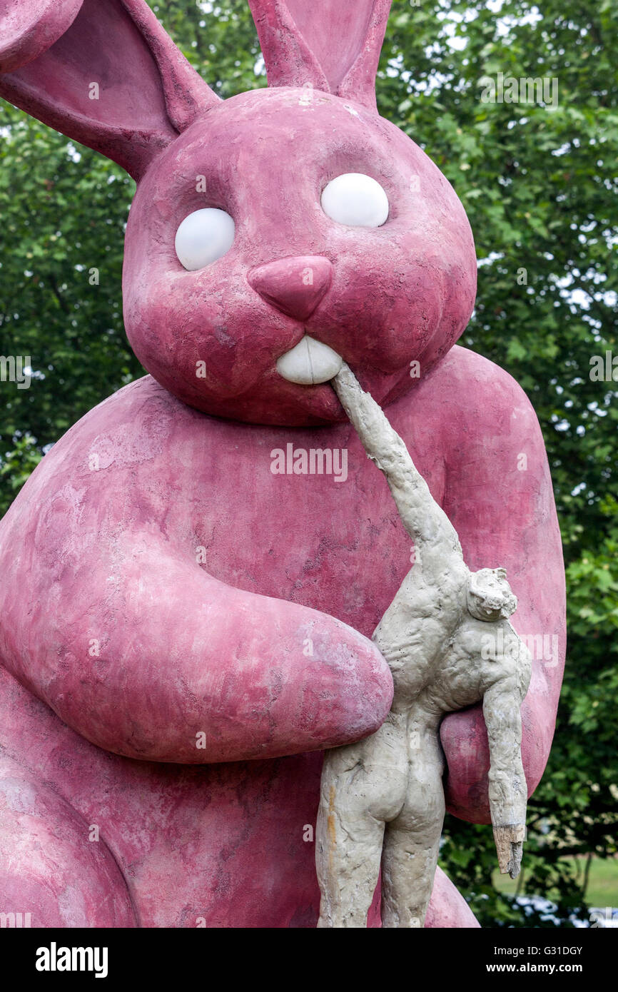 Statue of a pink rabbit that eats human, concrete sculpture on the housing estate Plzen, Pilsen Czech Republic art Stock Photo