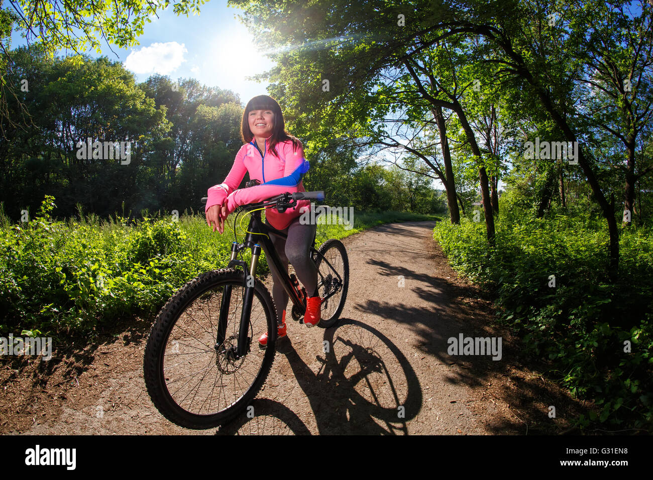 Young woman having fun riding a bicycle in the park Stock Photo - Alamy