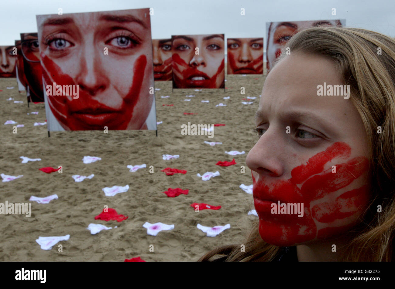 Rio De Janeiro, Brazil. 6th June, 2016. A woman walks in front of images of women displayed during a protest against the abuses to women, at Copacabana Beach, in Rio de Janeiro, Brazil, on June 6, 2016. Credit:  Severino Silva/AGENCIA ESTADO/Xinhua/Alamy Live News Stock Photo