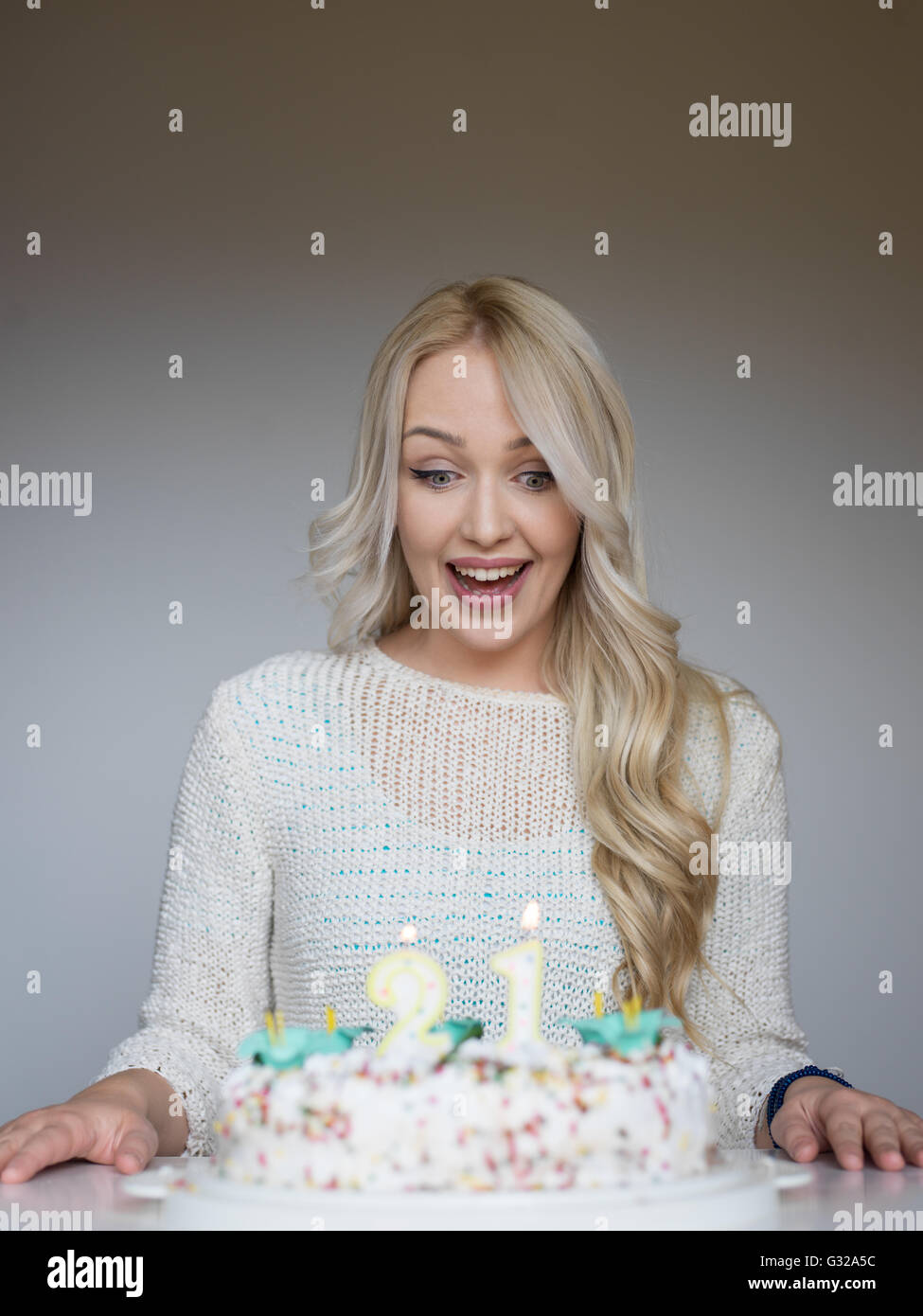 Portrait of a young beautiful blond girl holding plate with birthday ...