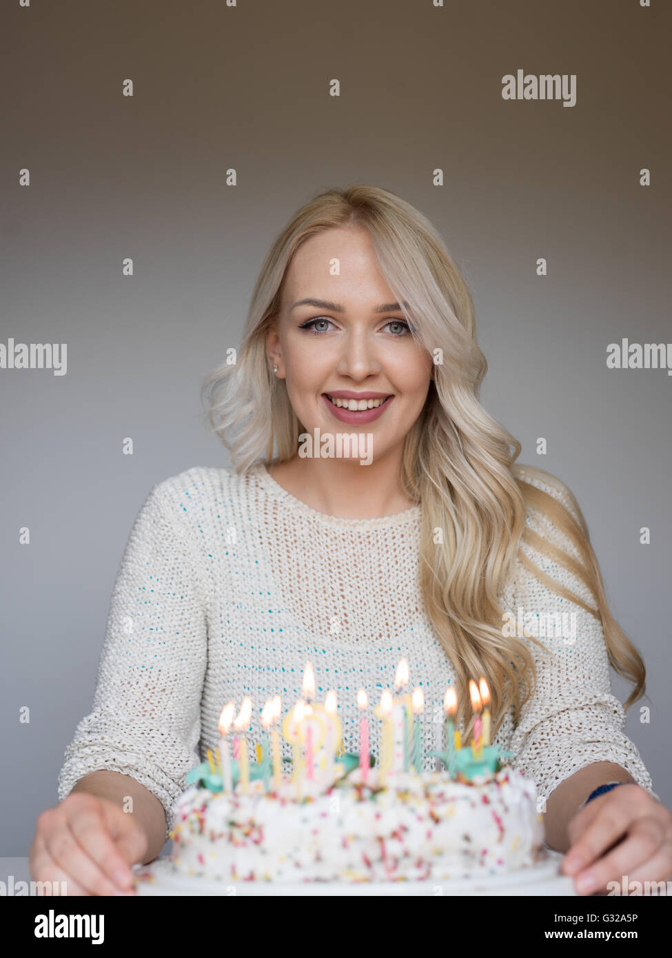 Portrait of a young beautiful blond girl holding plate with birthday ...