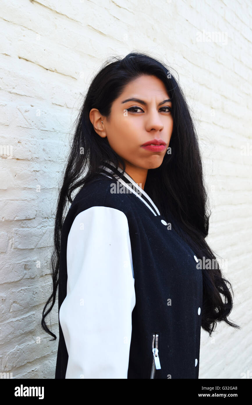 Portrait of young latin woman outdoors. Trendy and urban clothes. Stock Photo
