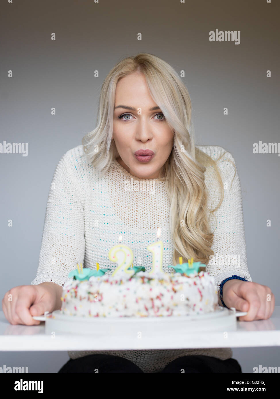 Portrait of a young beautiful blond girl holding plate with birthday ...