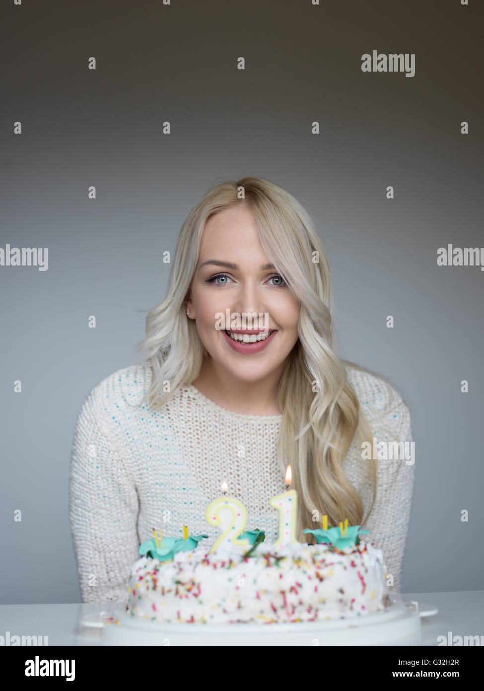 Portrait of a young beautiful blond girl holding plate with birthday ...