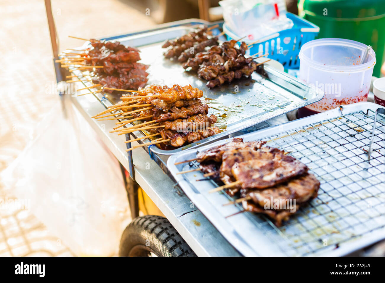 cooking meat skewers on the grill in a thai food street market in