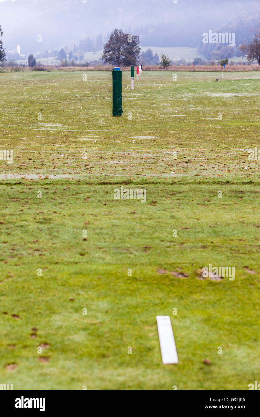 the driving range on a rural golf course with yardage poles Stock Photo