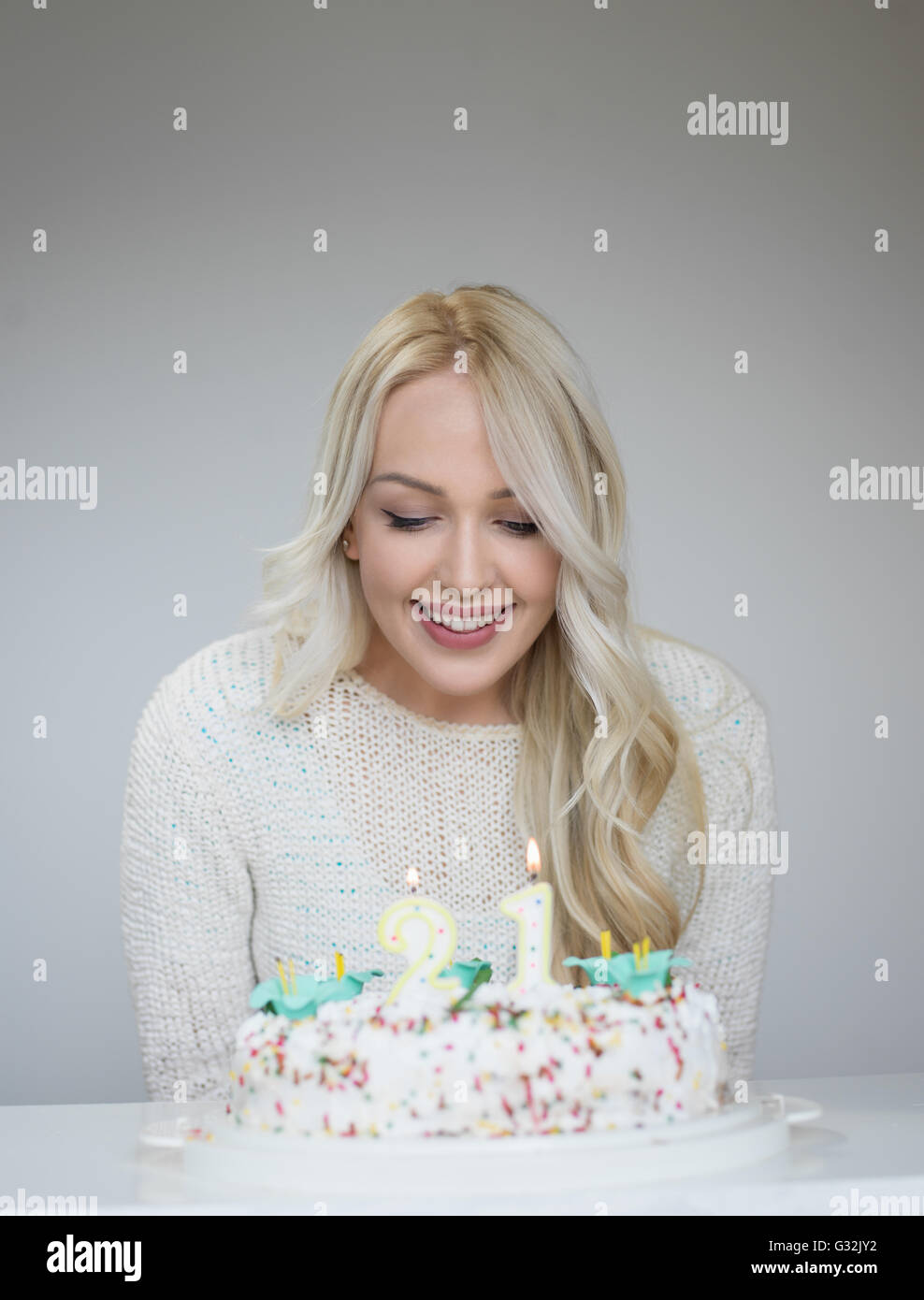 Portrait of a young beautiful blond girl holding a plate with birthday ...