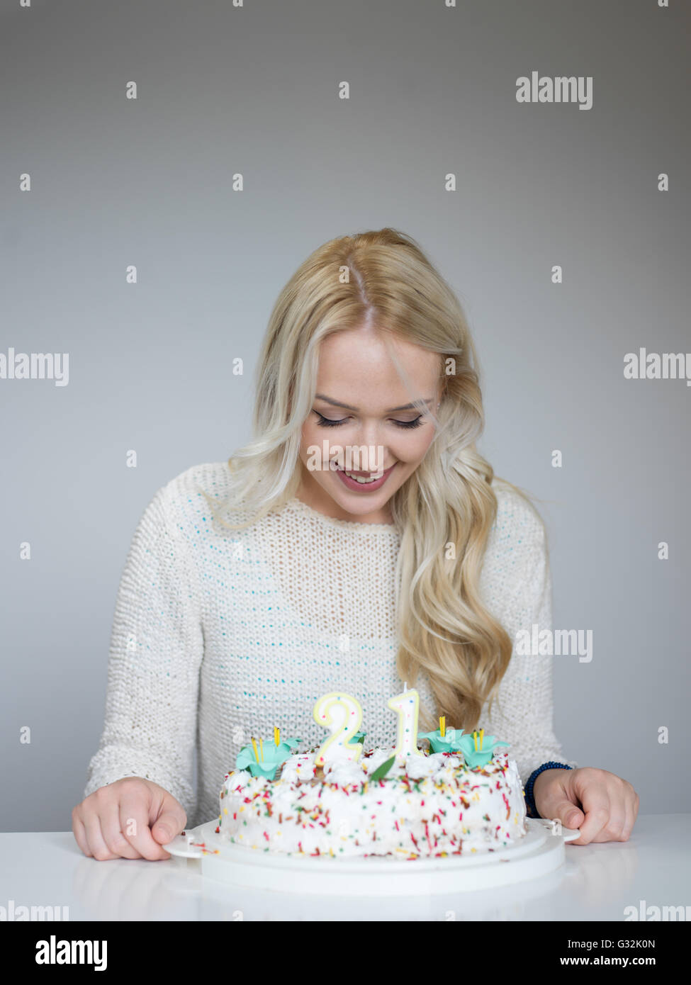 Portrait of a young beautiful blond girl holding plate with birthday ...