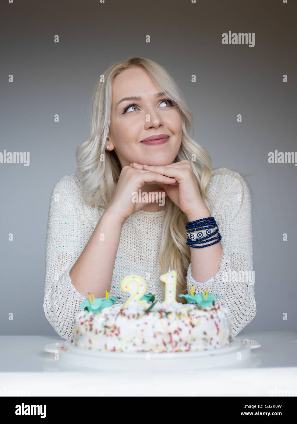 Portrait of a young beautiful blond girl holding plate with birthday ...