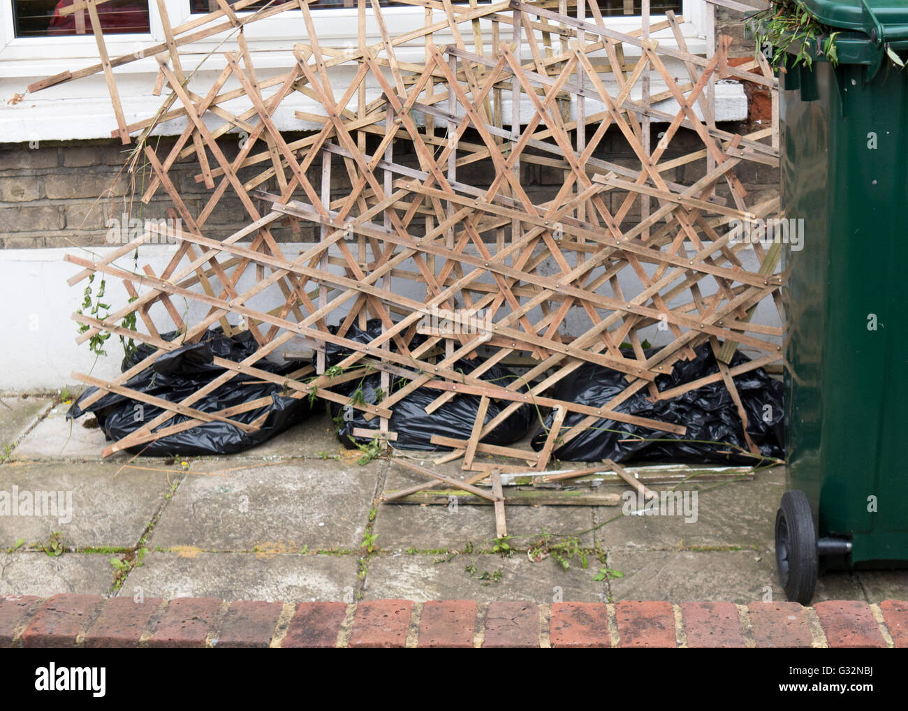 Broken garden trellis panels dumped in front a house. Stock Photo