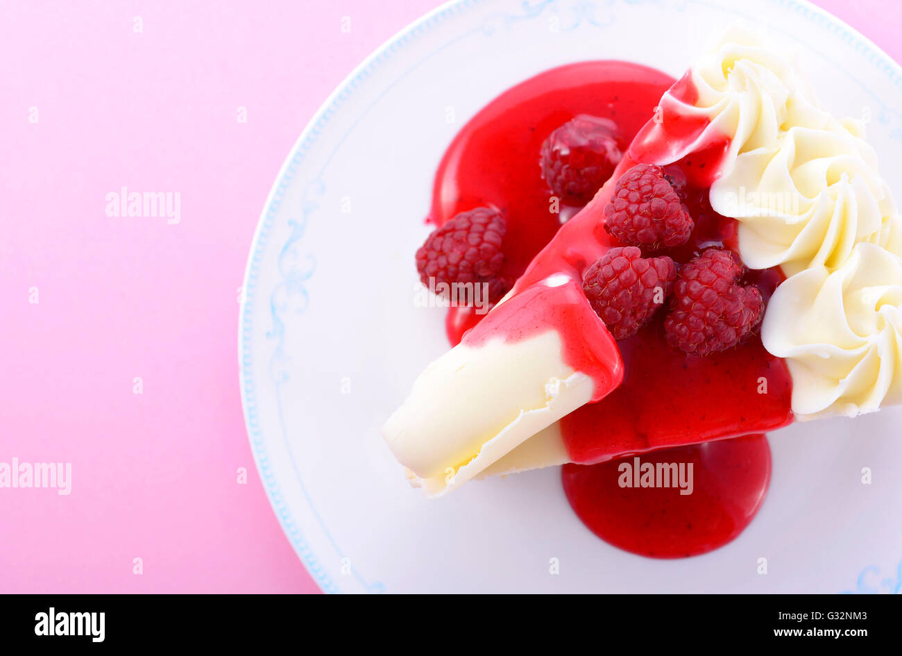 Slice of white chocolate cake with raspberry coulis and fresh ...