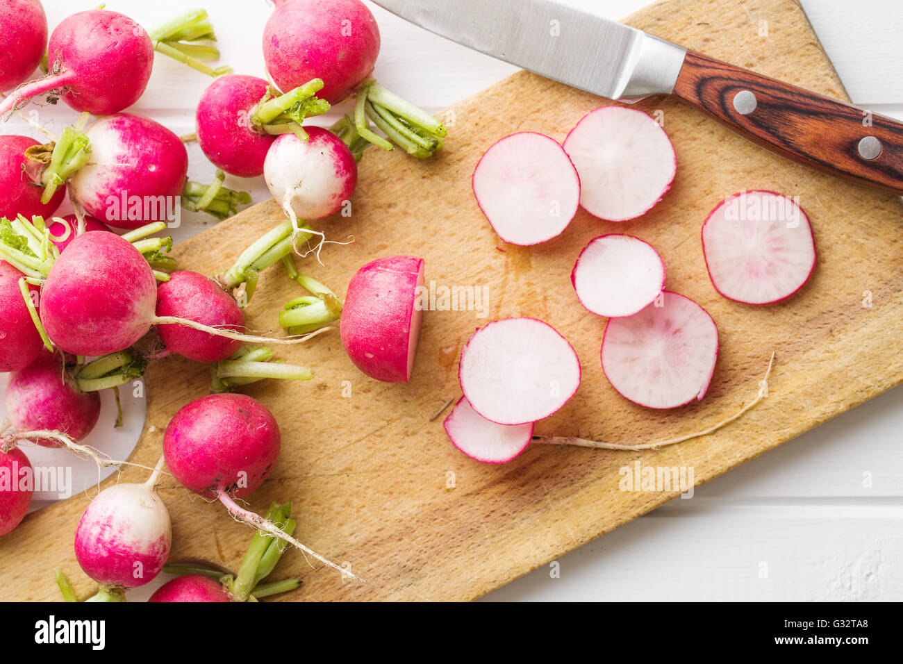 https://c8.alamy.com/comp/G32TA8/fresh-radishes-on-old-cutting-board-with-knife-sliced-red-radishes-G32TA8.jpg