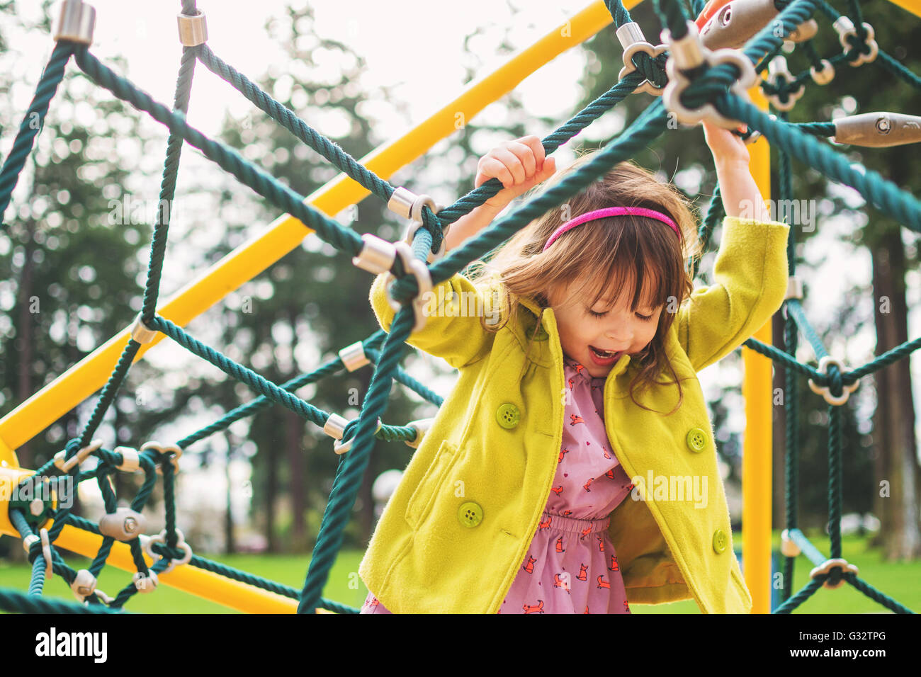 Girl playing on climbing ropes in playground Stock Photo Alamy