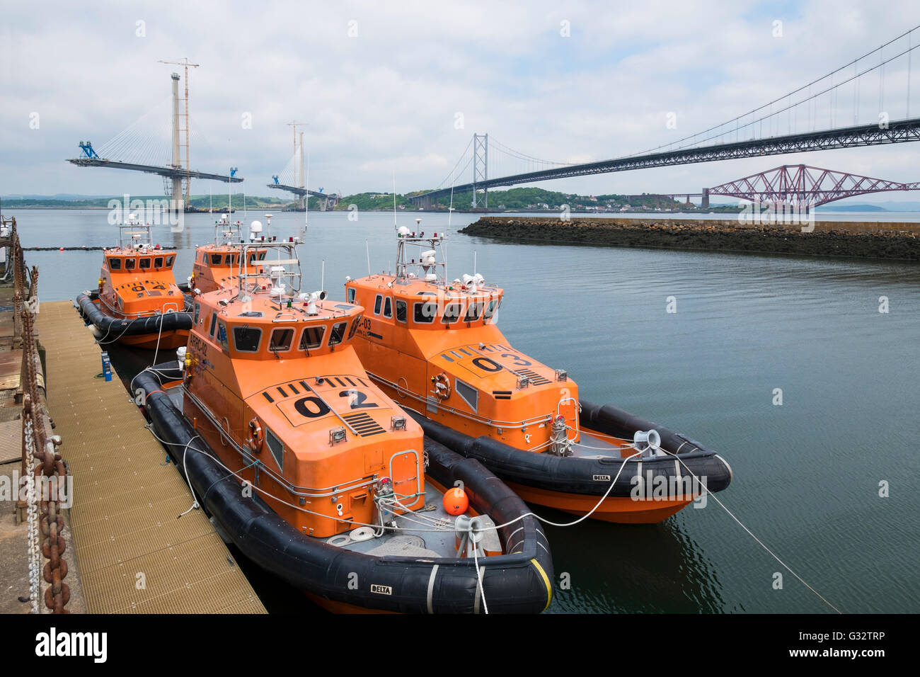View of three bridges crossing the River Forth and modern lifeboats at South Queensferry in Scotland United Kingdom. Stock Photo