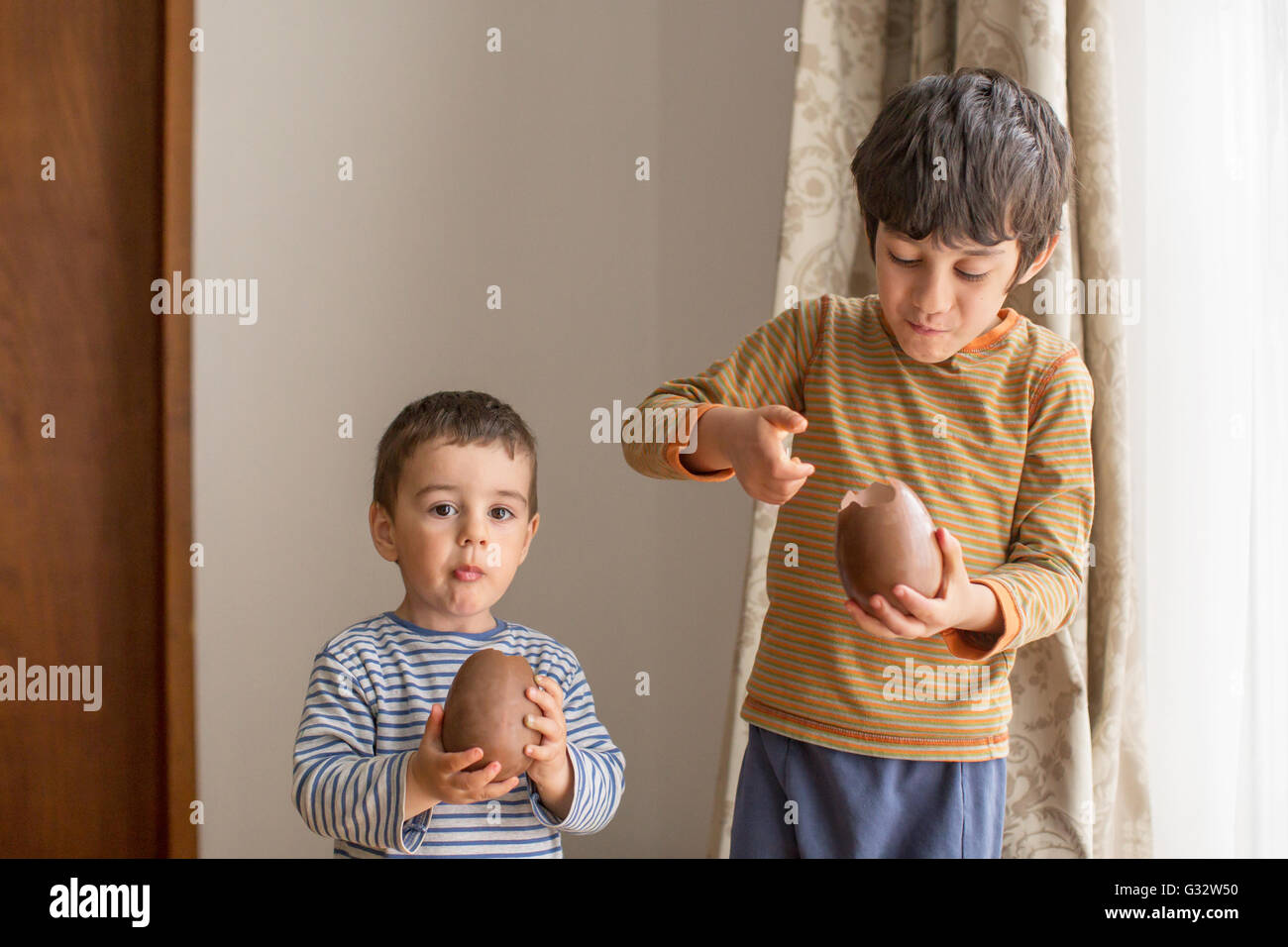 Two boys eating large chocolate easter eggs Stock Photo Alamy