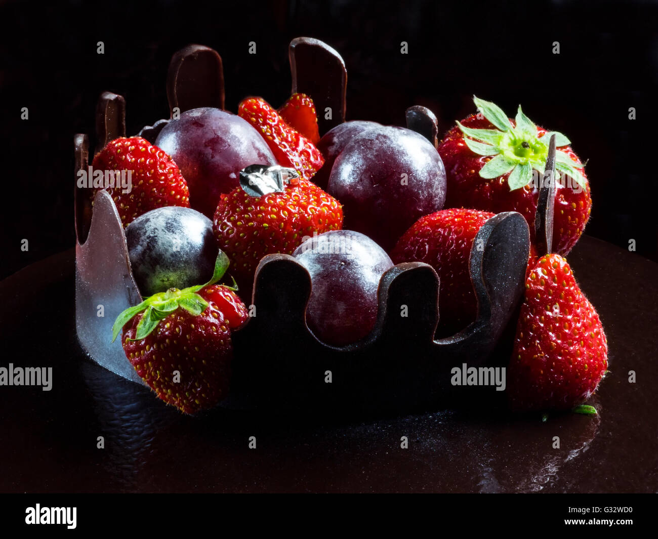 Sweet chocolate cake with strawberries and plums Stock Photo