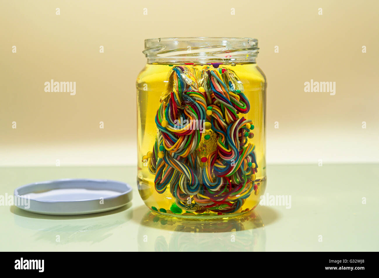 Conceptual brain in glass jar of oil made from multi coloured wires Stock Photo