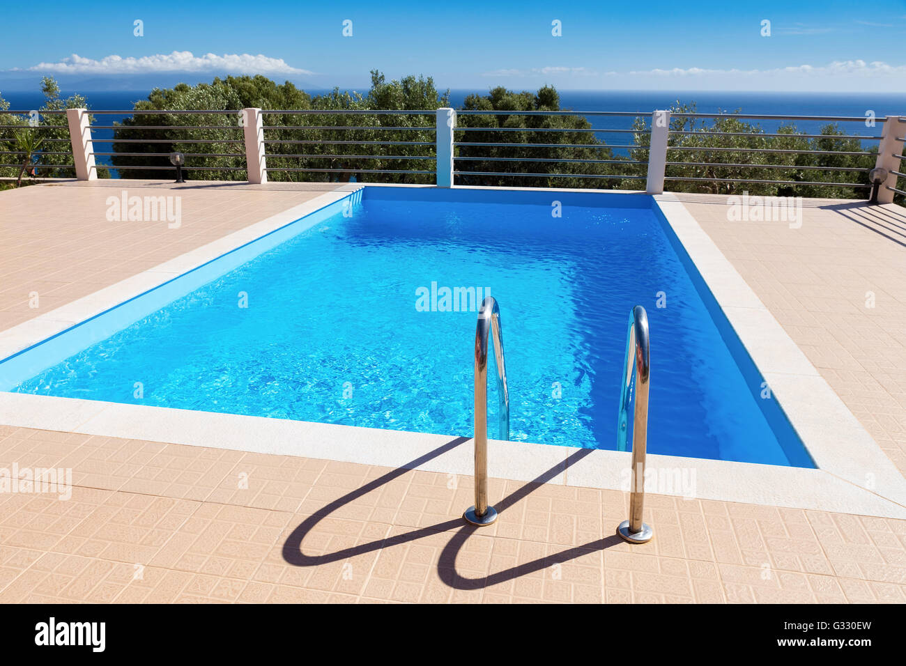 Water in blue swimming pool near sea in greece during summer season Stock Photo