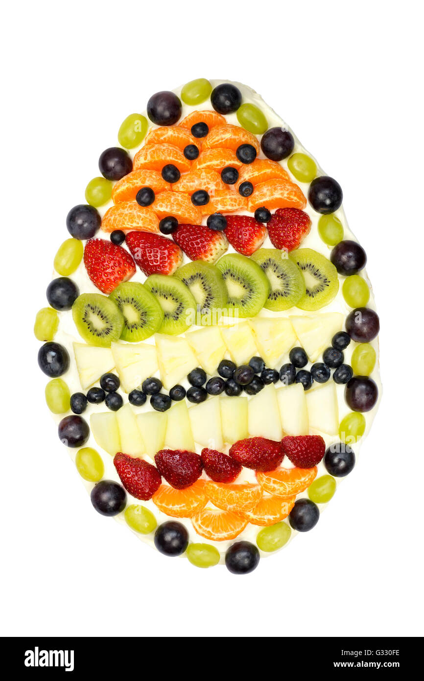 Egg shaped fruit cake covered with various fruits isolated on white background Stock Photo