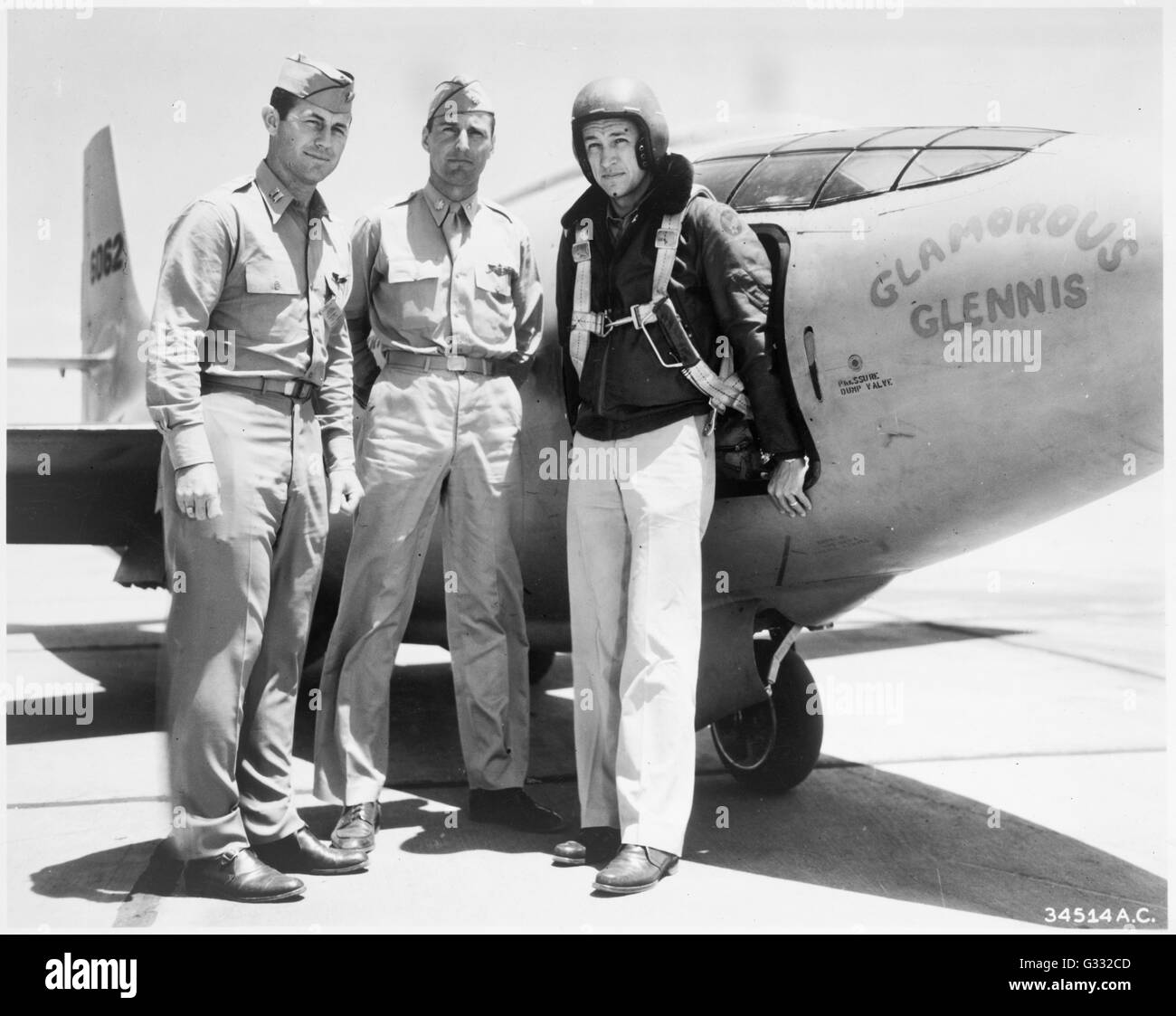 'Chuck' Yeager, Gus Lundquist, and Jim Fitzgerald (l-r) wearing a flight jacket, standing next to the Bell XS-1 rocket research airplane 'Glamorous Glennis.' Stock Photo