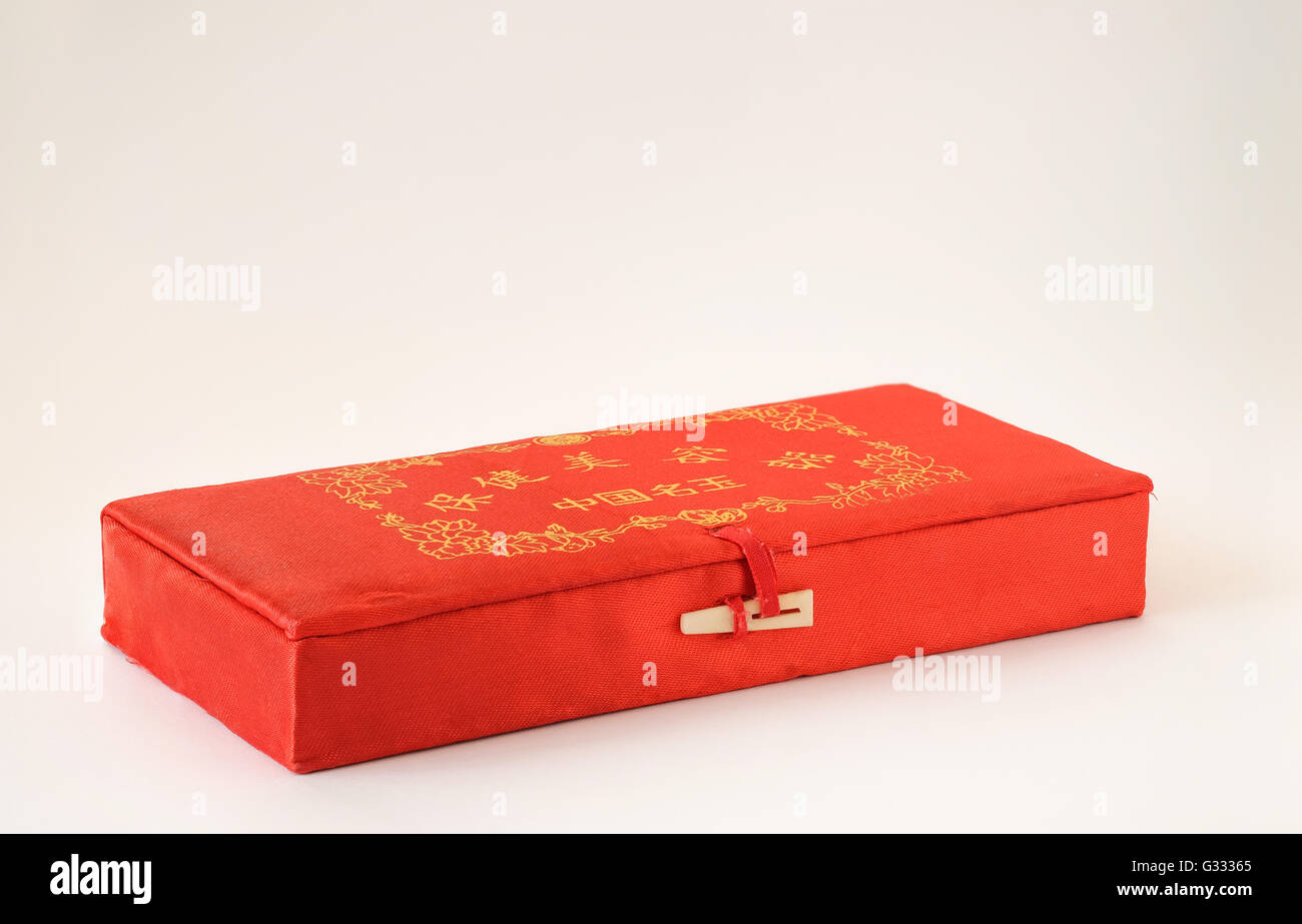 Decorative Chinese fabric box in red and gold on white background Stock Photo