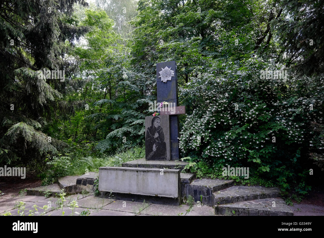 A memorial to WW2 victims in the deserted village of Zalissya located inside the Chernobyl Exclusion Zone in Ukraine on 04 June 2016. The Chernobyl accident occurred on 26 April 1986 at the Chernobyl Nuclear Power Plant in the city of Pripyat and was the worst nuclear power plant accident in history in terms of cost and casualties. Stock Photo