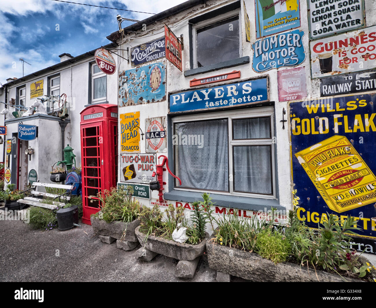 Building covered with tin advertising signs including a K6 telephone kiosk at Horseleap, County Offaly, Southern Ireland. Stock Photo