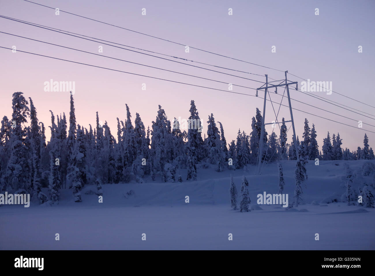 ?k skero, Finland, frozen power lines and utility pole at dusk Stock Photo