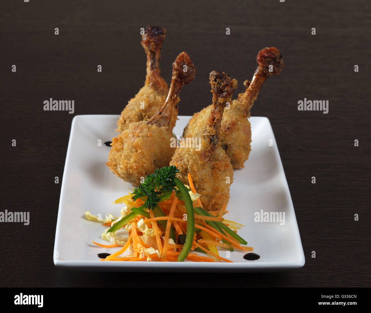 Kara-age. Fried chicken legs breaded and vegetarian side dish with sauce.  Decorating a dish of Japanese and Asian cuisine. Whit Stock Photo