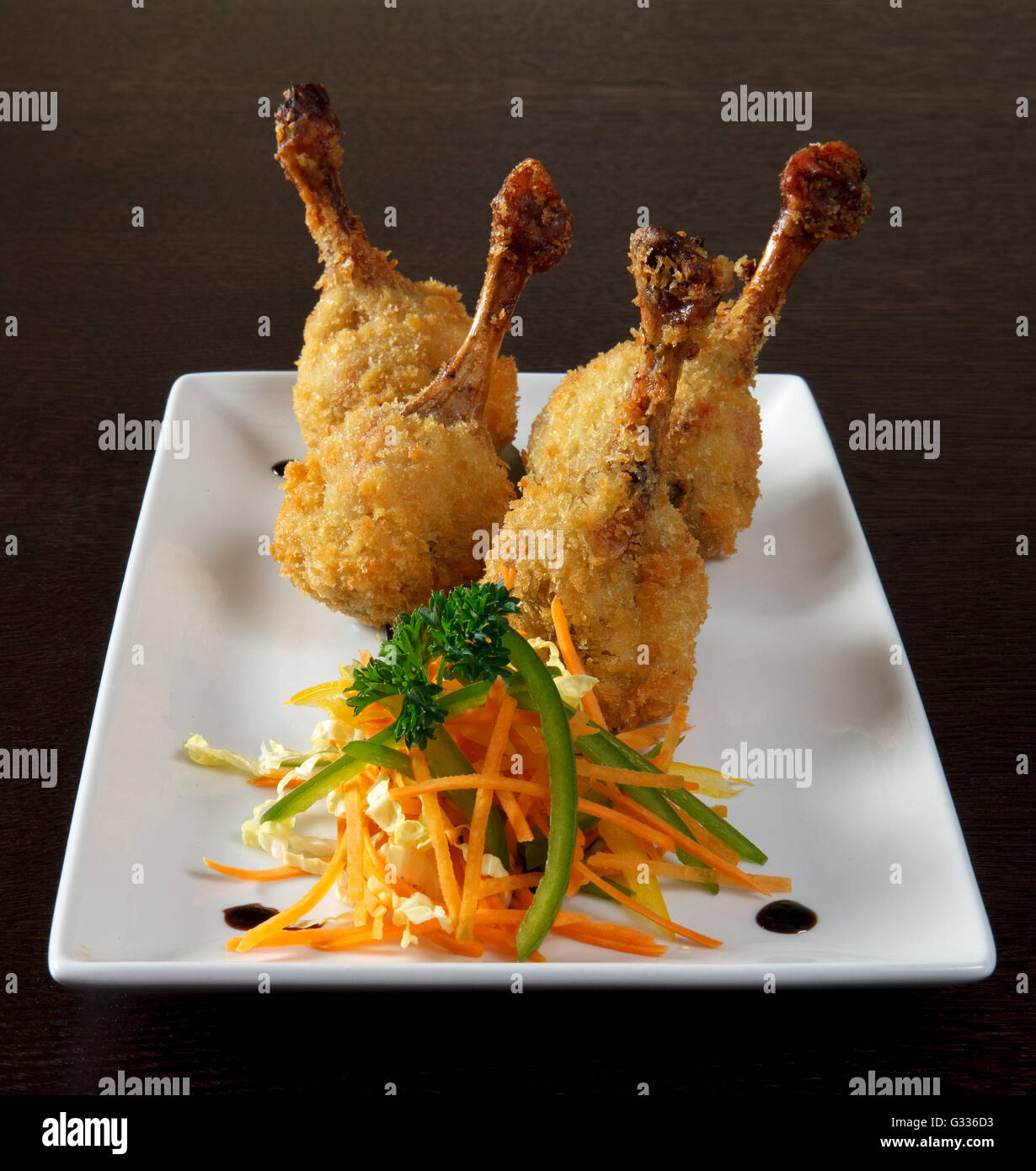 Kara-age. Fried chicken legs breaded and vegetarian side dish with sauce.  Decorating a dish of Japanese and Asian cuisine. Whit Stock Photo