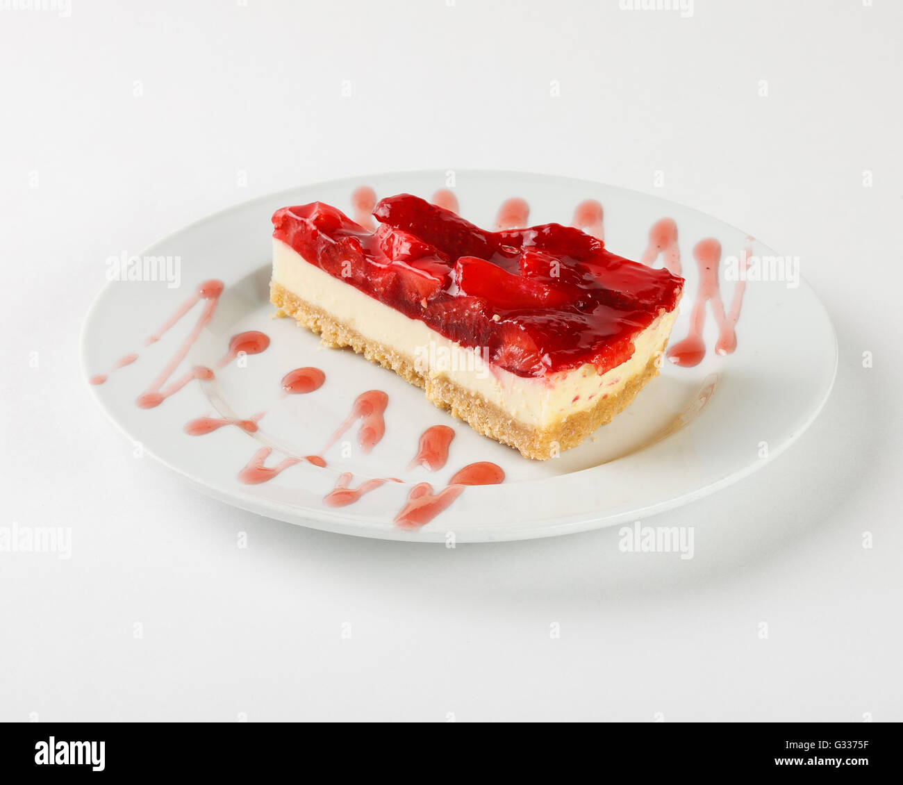 Delicious cheesecake with strawberry jelly and jam on the plate on white background. Close up side view. Stock Photo