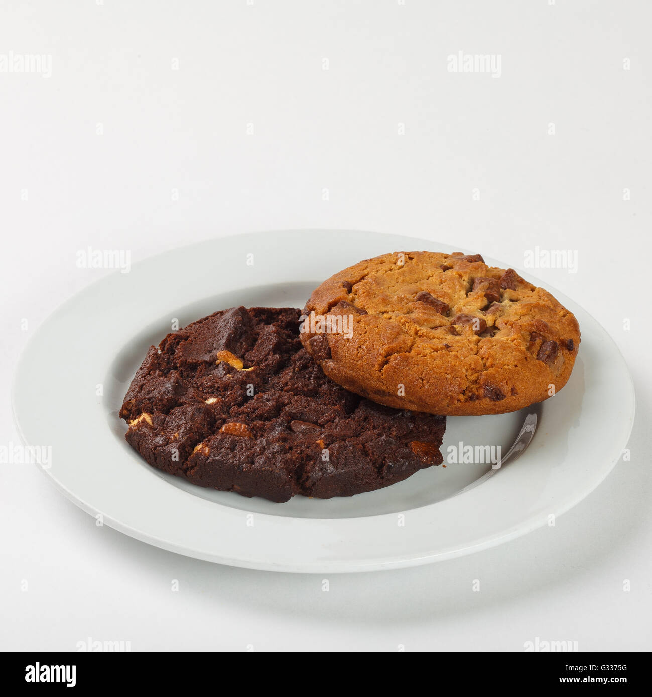 Delicious biscuit cookies with chocolate chips on the plate on white background. Close up side view. Stock Photo