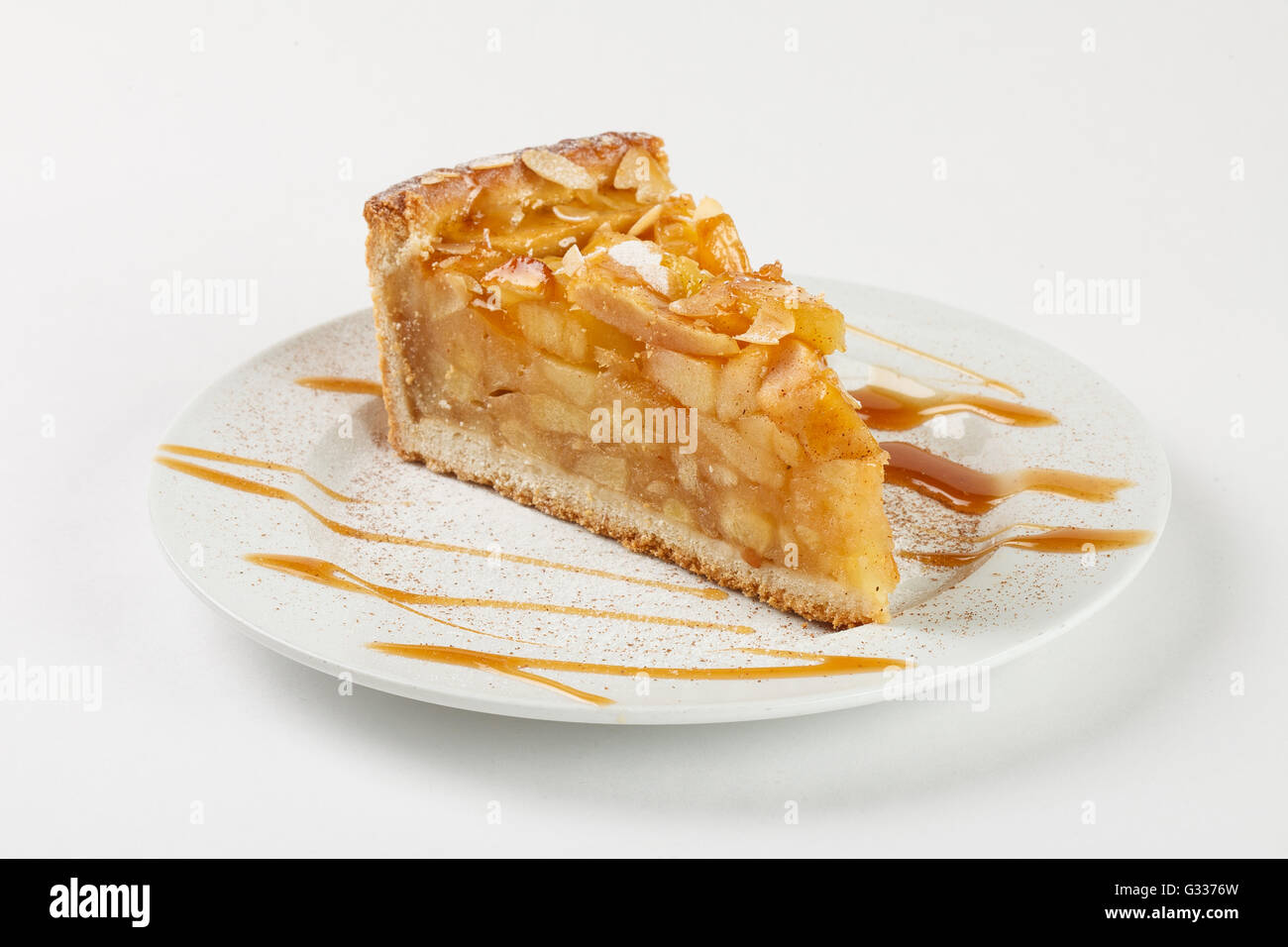 Delicious apple pie charlotte with caramel on the plate on white background. Close up side view. Stock Photo